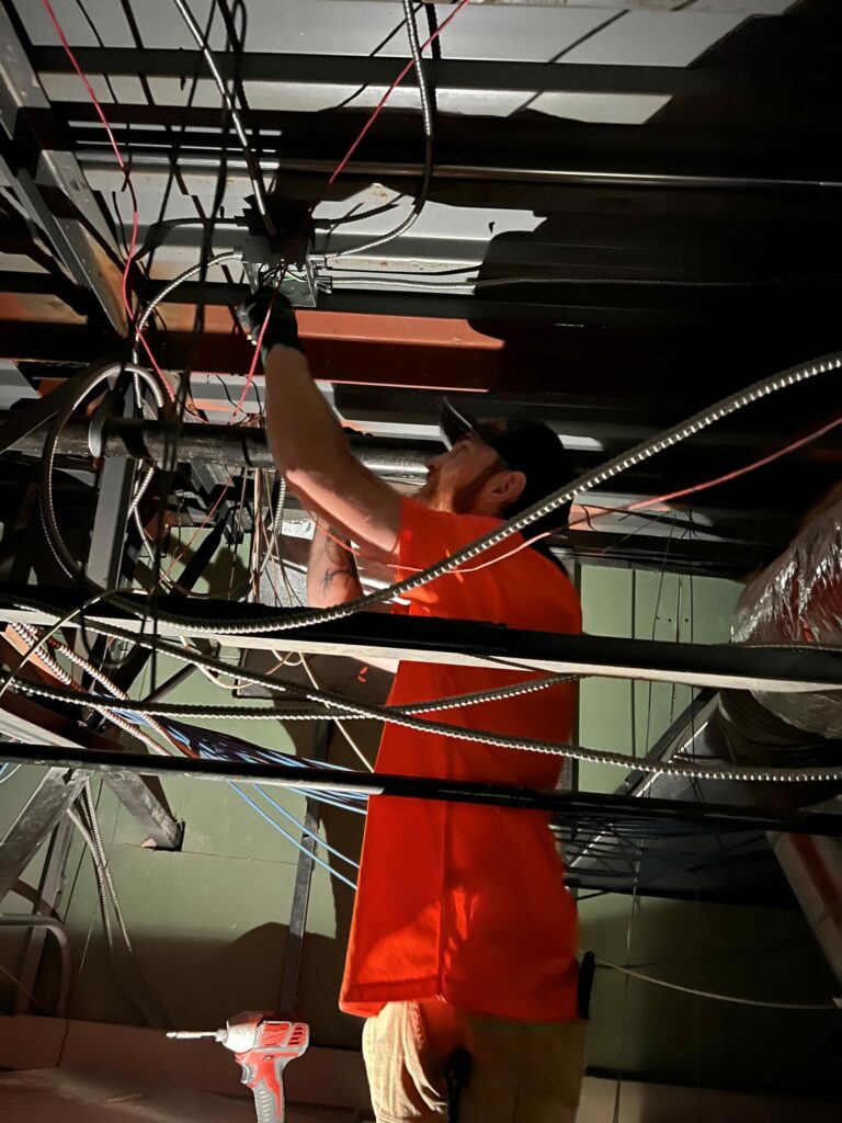 Electrician working on industrial wiring system