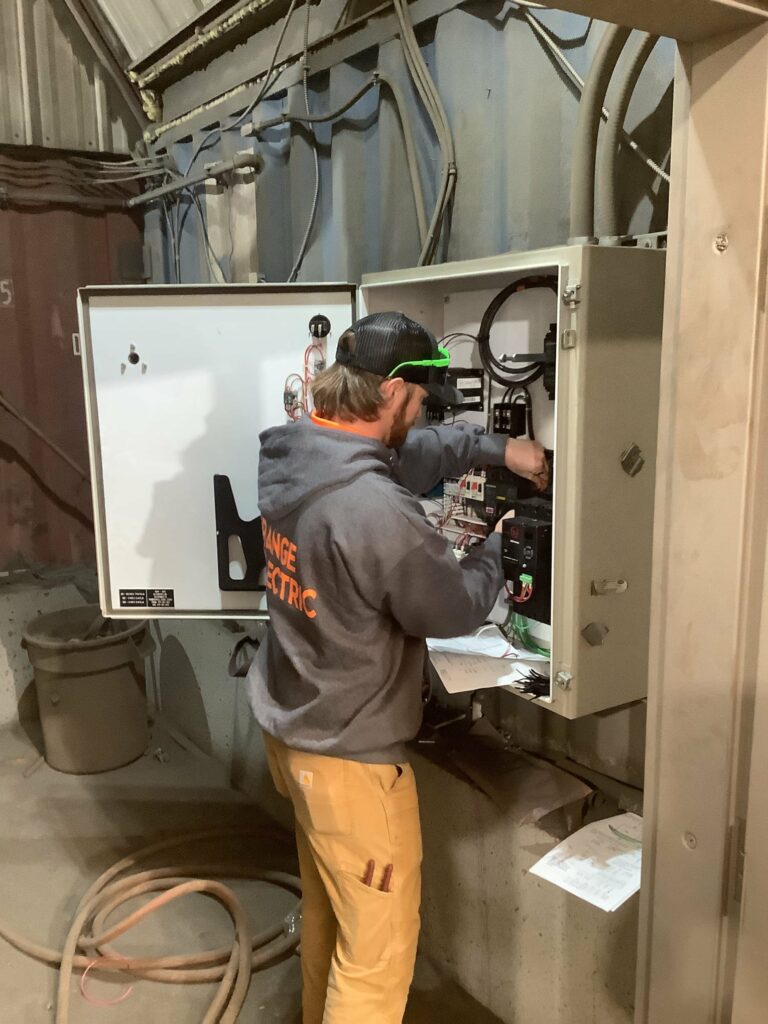 Technician working on industrial cabinet wiring